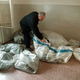 Montgomery County coroner Ed Rovere examines a body at the Rockville Adult Learning Annex, where RIF extremists killed 52 illiterates with a pipe bomb Friday. Experts say reading-is-fundamentalism is a growing movement in the U.S.
